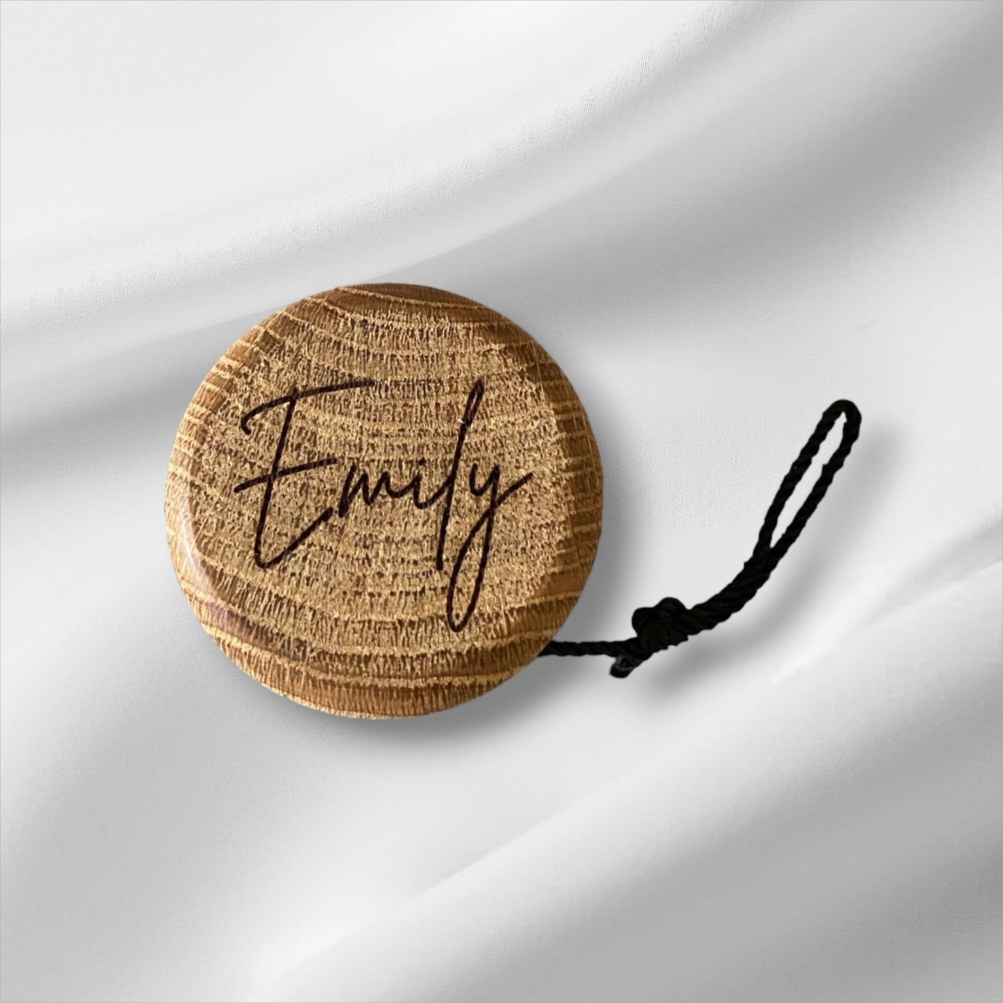Elegant wooden yo-yo made of oiled oak and black cord with loop